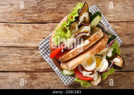 Rezept für einen Sabich ein mittelöstliches Sandwich enthält gebratene Auberginen, gekochtes Ei, Hummus und anderes Gemüse aus nächster Nähe auf dem Tisch. Horizontal oben V Stockfoto