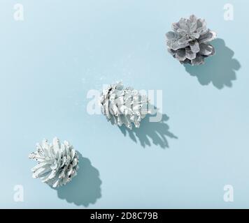 Drei glänzende Kegel mit Schatten auf blauem Papierhintergrund, Draufsicht Stockfoto