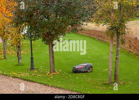 Roboter-Rasenmäher bei der Arbeit in einem großen Garten in Schottland. Stockfoto