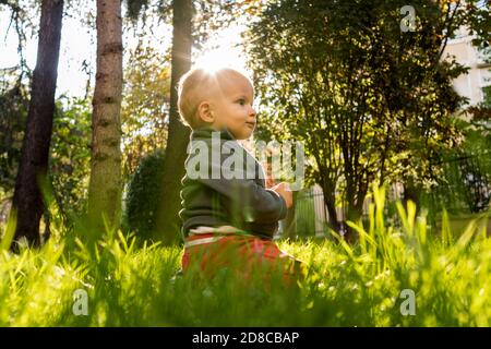 Baby sitzt auf Gras Stockfoto