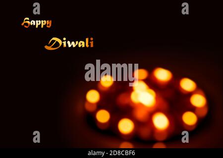 Happy Diwali Hintergrundbild mit Text und Copy Space. Ein abstraktes, unscharfes Bild von beleuchteten Diya-Öllampen oder Kerzen. Indische Hindu festliche Feier gr Stockfoto