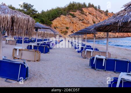 Strände von Griechenland, Abend am leeren Metalia Strand, Sonnenschirme und Liegestühle, Thassos, Griechenland Stockfoto