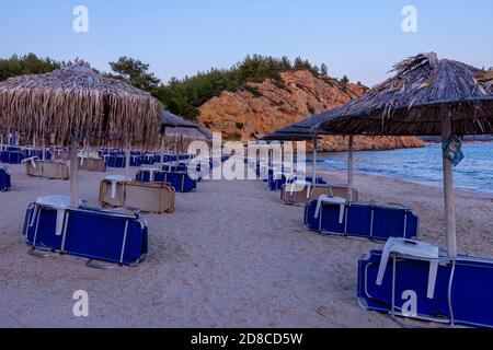 Strände von Griechenland, Abend am leeren Metalia Strand, Sonnenschirme und Liegestühle, Thassos, Griechenland Stockfoto