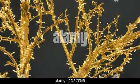 Gelber künstlicher Weihnachtsbaum aus einer Girlande auf den Straßen der Stadt. Stockfoto