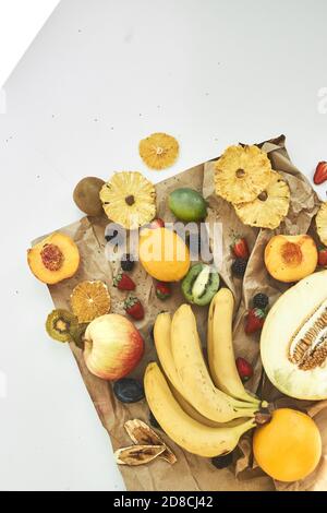 Frisches Obst und Fruchtchips liegen auf einem weißen Tisch. Detox-Konzept. Stockfoto