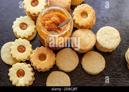 Herstellung von traditionellen rustikalen linzer Keks Cookies vintage Backen mit einem Einmachglas mit Marmelade Stockfoto