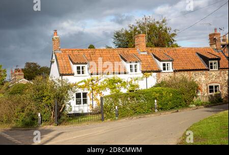 Regenstürme Wolken über ziemlich attraktiven Hütten im Dorf Blaxhall, Suffolk, England, Großbritannien Stockfoto