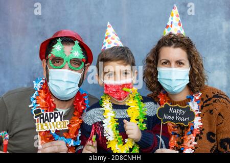 Glückliche Familie mit Gesichtsmasken feiern Silvester Stockfoto
