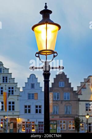 Historische Laterne vor den Giebelhäusern am Marktplatz am Abend, Deutschland, Schleswig-Holstein, Nordfriesland, Friedrichstadt Stockfoto