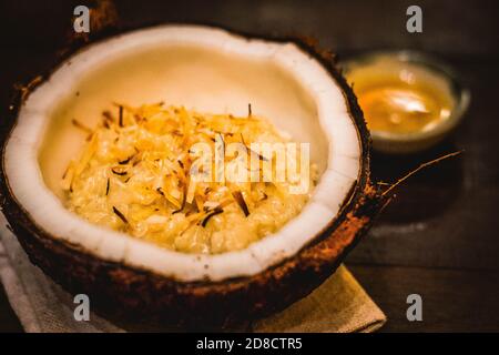 Ein traditionelles thailändisches Dessert mit Reispudding in Kokosmilch Serviert mit getrockneter Kokosraspel auf der Oberseite Stockfoto
