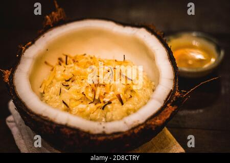 Ein traditionelles thailändisches Dessert mit Reispudding in Kokosmilch Serviert mit getrockneter Kokosraspel auf der Oberseite Stockfoto