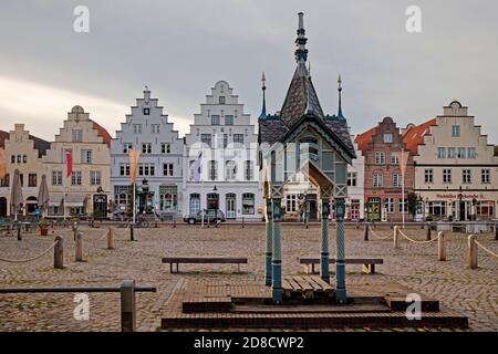 Historische Wasserpumpe auf dem Marktplatz vor Häusern mit Stufengiebeln, Deutschland, Schleswig-Holstein, Nordfriesland, Friedrichstadt Stockfoto