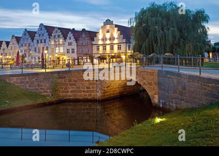 Brücke über den Mittelburggraben mit den Giebelhäusern am Abend, Deutschland, Schleswig-Holstein, Nordfriesland, Friedrichstadt Stockfoto