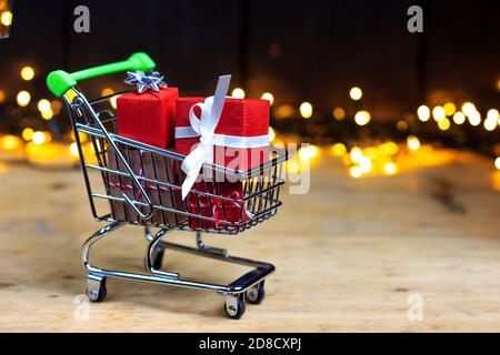 Einkaufswagen mit Boxen, Geschenken. Shopping für Weihnachten, Black Friday, Stockfoto
