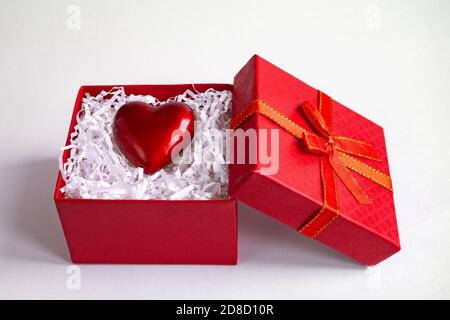 Rote Geschenkbox mit Herz auf weißem Hintergrund, St. Valentinstag Konzept Stockfoto