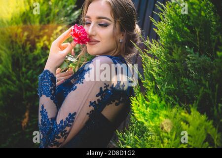 Schönes Mädchen in glamourösen ultramarine Kleid riecht eine Rose. Bereit für ihre Abschlussball Nacht. Stockfoto