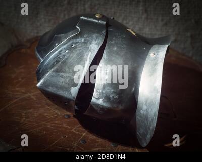 Shinny mittelalterlichen Helm auf einem hölzernen Schild. Stockfoto