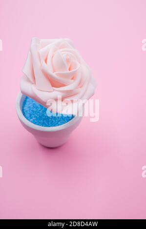 Nahaufnahme der künstlichen dekorativen rosa Rose in einem Topf Auf der rosa Oberfläche - Platz für Text Stockfoto
