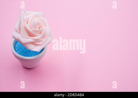 Nahaufnahme der künstlichen dekorativen rosa Rose in einem Topf Auf der rosa Oberfläche - Platz für Text Stockfoto