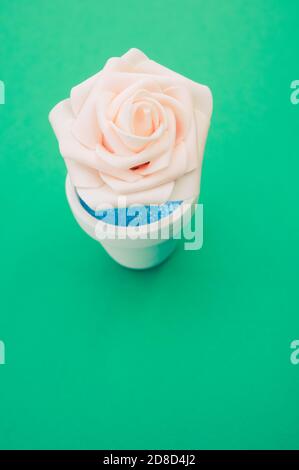 Nahaufnahme der künstlichen Zierrose im Topf Die grüne Fläche - Platz für Text Stockfoto