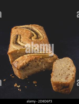 Scheiben Bananennussbrot Brot auf dem dunklen Hintergrund platziert. Hausgemachtes köstliches Gebäck. Nahaufnahme. Stockfoto