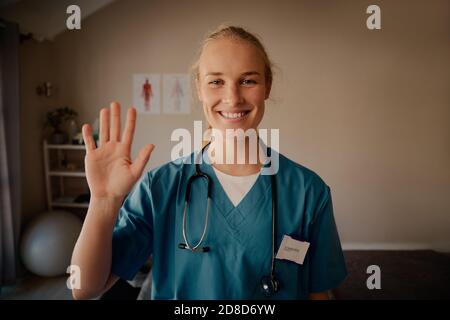 Portrait von lächelnd schöne junge Krankenschwester winken Hand mit Stethoskop Stockfoto