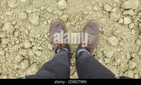 Draufsicht eines Mannes Beine und Schuhe auf gelb Graue Erde Stockfoto