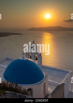 Fira, Thira, Santorini Island, Griechenland - 18. September 2020: Übernahme der katholischen Kirche der Seligen Jungfrau Maria, drei Glocken. Blick auf den Sonnenuntergang Stockfoto