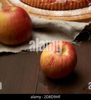 Rote reife Äpfel liegen auf einem braunen Holztisch, Nahaufnahme Stockfoto