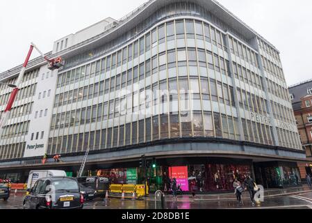 London, Großbritannien. 29. Oktober 2020. Arbeiter installieren Weihnachtsbeleuchtung an der Außenseite des Peter Jones Kaufhauses in Sloane Square. Das Geschäft ist Teil der John Lewis-Gruppe, deren Flagship-Store in der Oxford Street die Erlaubnis erhalten hat, die Hälfte des Gebäudes in Büros umzuwandeln, da das Unternehmen einen Umstrukturierungsplan durchläuft, um einen Rückgang der Geschäftsleistung während der laufenden Coronavirus-Pandemie einzudämmen. Darüber hinaus wird den Mitarbeitern erstmals seit 1953 kein jährlicher Bonus gezahlt. Kredit: Stephen Chung / Alamy Live Nachrichten Stockfoto