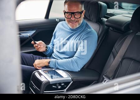 Schöner bärtiger Mann lächelt im Auto Stockfoto