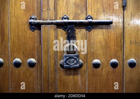 Holztür mit Verriegelung und Vorhängeschloss Stockfoto