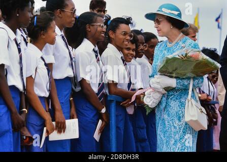 Eine Reihe lokaler Studenten und Schüler grüßen ihre Königliche Hoheit Königin Elisabeth II. Bei ihrem Besuch im Queen's College. Ihre Majestät war bei ihrem letzten Besuch auf der Karibikinsel Barbados. März 1989. Stockfoto