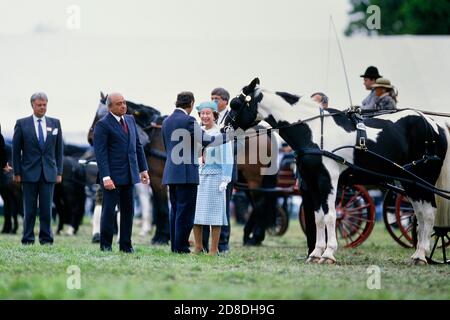 Eine lächelnde Königin Elizabeth II präsentiert Preise auf der Windor Horse Show begleitet von einem der Sponsoren der Show Mohammed Al Fayed vom Harrods Store. Herr Al-Fayed ist der Vater von Dodi Al-Fayed. The Royal Windsor Horse Show, Berkshire, England, Großbritannien. Mai 1989 Stockfoto