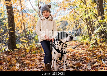 Mädchen mit Dalmatianer Hund in der Herbstsaison Stockfoto