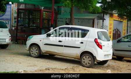 22. September 2020 : Mahroli, Rajasthan, Indien / weißes Auto war Parken am Straßenrand auf Markthintergrund. Stockfoto