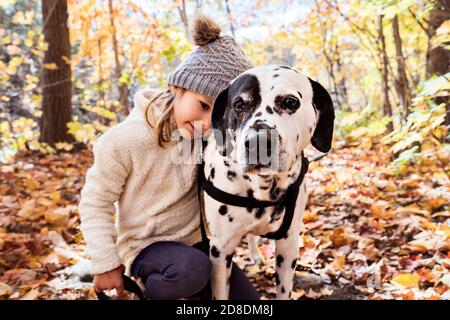 Mädchen mit Dalmatianer Hund in der Herbstsaison Stockfoto