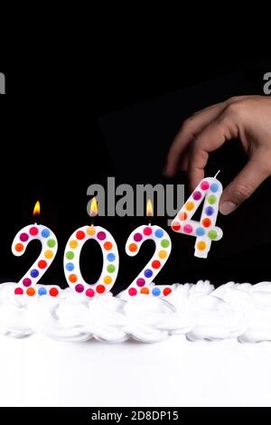 Vier weiße Kerzen Zahlen Flamme Frohes neues Jahr 2023 Hand Schwarzer Hintergrund Stockfoto