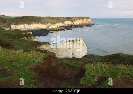 Sonnenaufgang über Meer und Klippen unter hellem Herbsthimmel bei Ebbe entlang der Nordostküste entlang Flamborough Head in East Riding of Yorshire, Großbritannien. Stockfoto