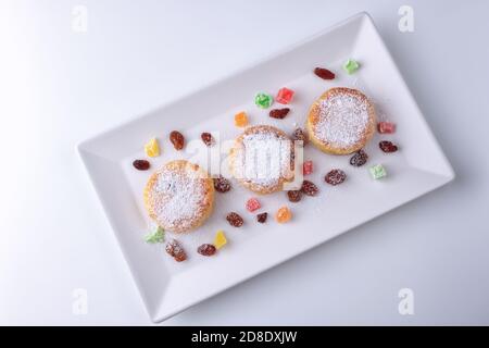 Quark Pfannkuchen mit Rosinen und kandierten Früchten auf einem weißen Teller, Draufsicht Stockfoto