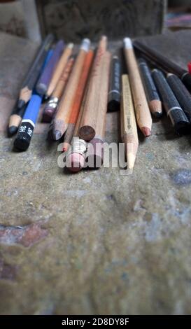 Wählen Sie den Fokus auf eine Vielzahl von Graphit- und Buntstiften Auf einem Holztisch im Atelier eines Künstlers Stockfoto