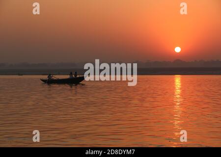 Silhouetten in einem Boot auf dem Ganges bei Sonnenuntergang Stockfoto