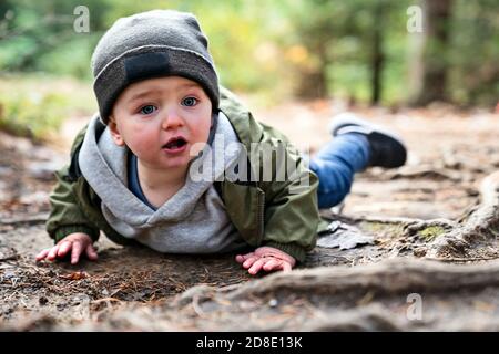 Junge verletzt, nachdem er in den Wald fiel traurig und unglücklich Kind weint Stockfoto