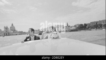 Ein glückliches Paar hat gerade in Venedig geheiratet und von einem Taxiboot begrüßt Stockfoto