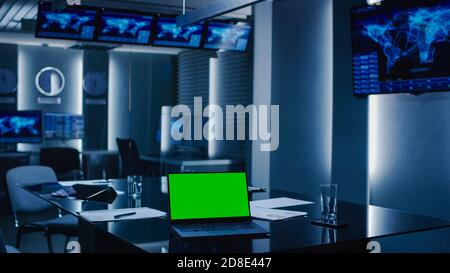 Aufnahme des Überwachungsraums der Systemsteuerung. Leeres Government Emergency Operations Center. Auf dem Bildschirm Table Laptop Showing Green Mock-up. Stockfoto