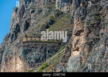 Steinbild des Inka-gottes Viracocha und Inka-Getreidespeicher in Ruinen, Ollantaytambo, Peru Stockfoto