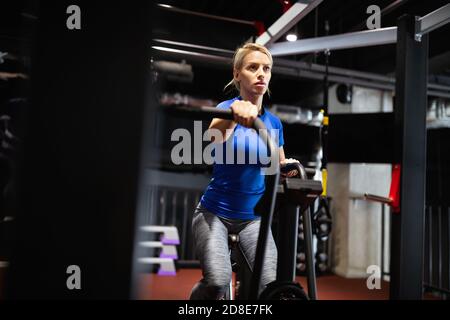 Fitness weibliche mit Air Bike für cardio Workout bei crossfit Fitnessraum. Stockfoto