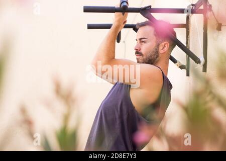 Schöner Sportler während seiner Outdoor-Training Pull-ups Stockfoto