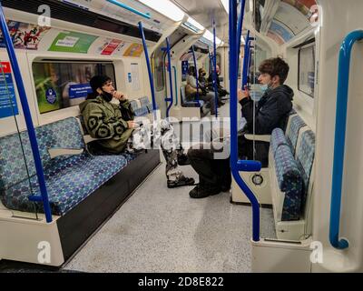 London, Großbritannien. 29. Oktober 2020. Passagiere, die mit der Londoner U-Bahn reisen, mit Facemasken unter ihren Chins. Das Tragen von Gesichtsmasken, um Nase und Mund zu bedecken, bleibt obligatorisch, um auf dem Schlauch zu reisen, da die Coronavirus-Pandemie weiter anhält und die Fälle weiter zunehmen. Mit dem Anstieg der Coronavirus-Fälle im Vereinigten Königreich ist das Kapital vor kurzem von Tier 1 auf Tier 2 Covid-Alarmstufe übergegangen. Kredit: Stephen Chung / Alamy Live Nachrichten Stockfoto