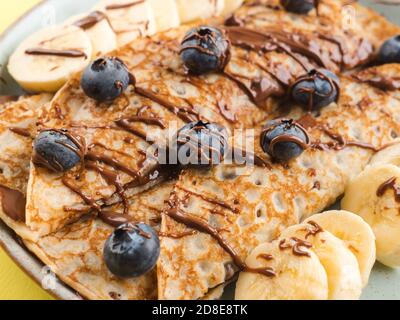 Crepes mit Schokoladennussaufstrich, Banane, Beeren Stockfoto